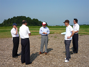 ウッドチップが敷かれた西部丘陵東地区のデモ区画でサンデン(株)堀越顧問（中央）のアドバイスに耳を傾ける